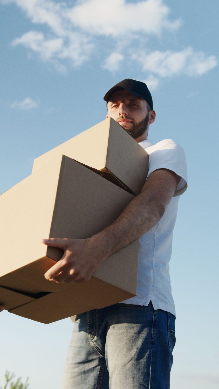 Déménageur portant de grands cartons